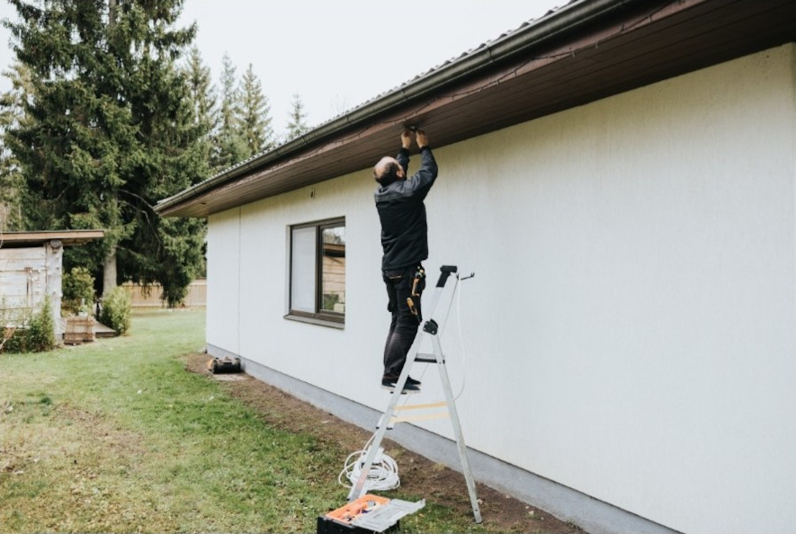 Elektriker installerar belysning på takfoten till en villa